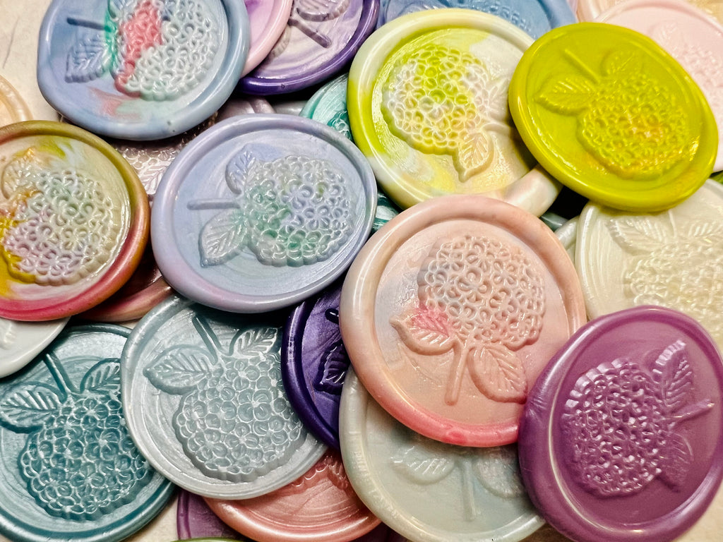 Close up view of the Hydrangea Bloom Wax Seal Stickers stacked into a pile