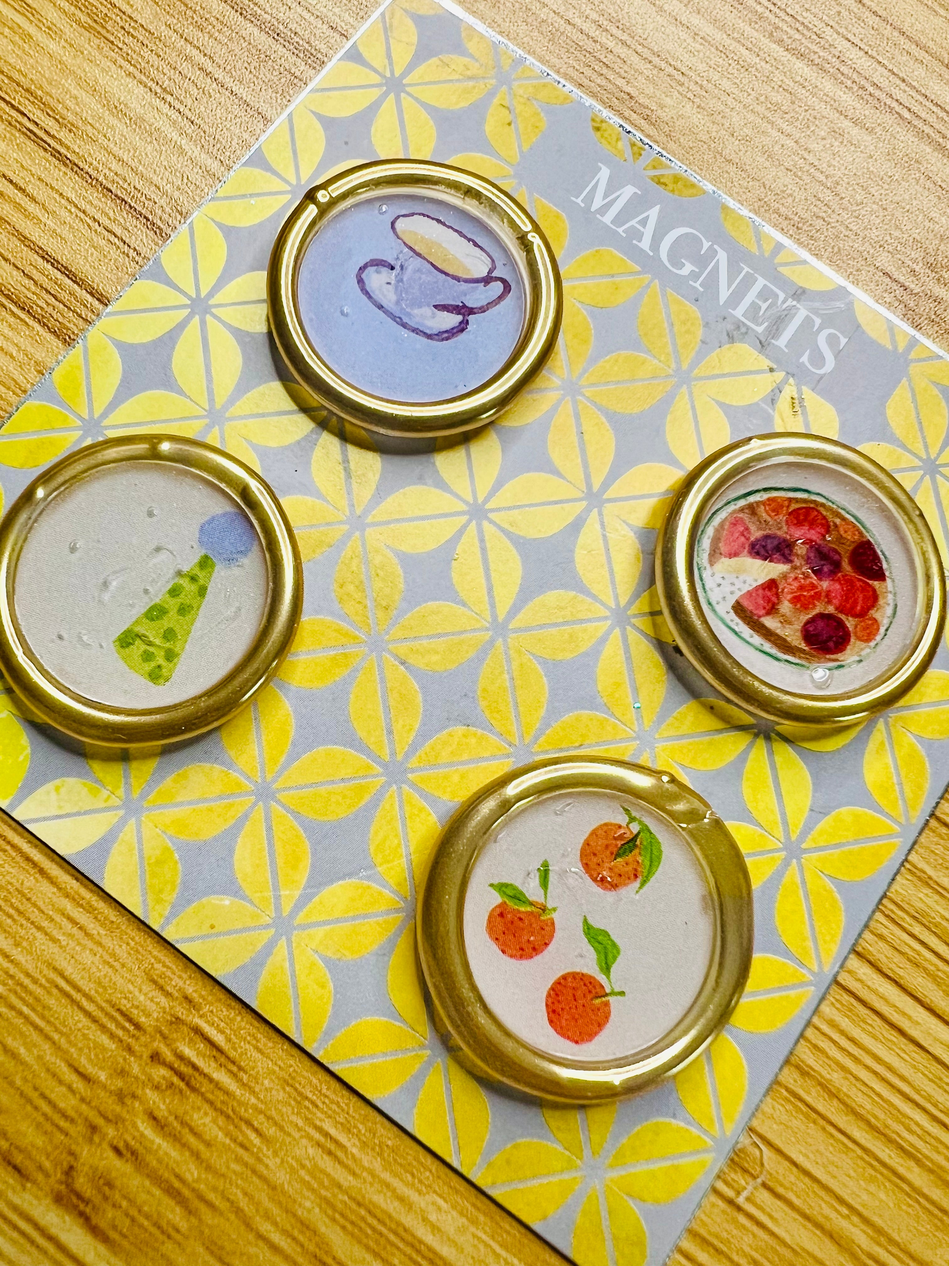 Set of four round magnets created by Rochambeau Home feature colorful wax seal magnets on a patterned card labeled 'Magnets'.
