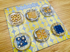 Set of six decorative magnets on a floral card labeled 'Magnets'.