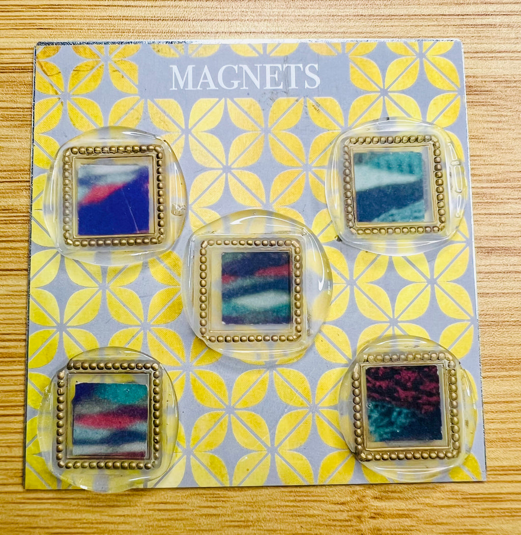 Set of colorful square wax seal magnets created by Rochambeau Home laid out on a 'Magnets' display 