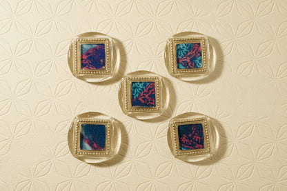 Set of five square wax seal magnets created by Rochambeau Home on a decorative background with floral pattern (deep gold)