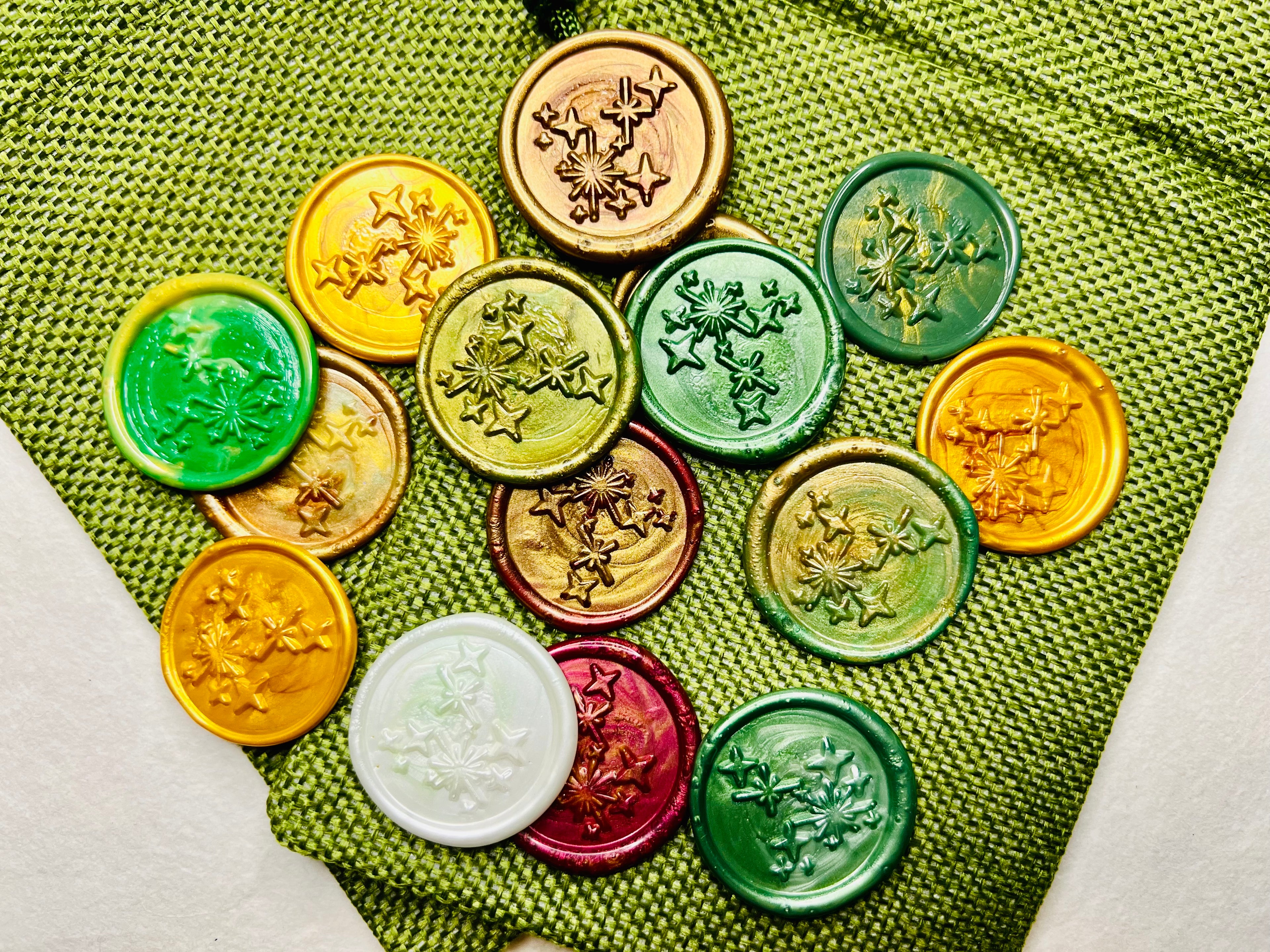 Colorful celestial embossed wax seal stickers in festive colors on a green burlap bag