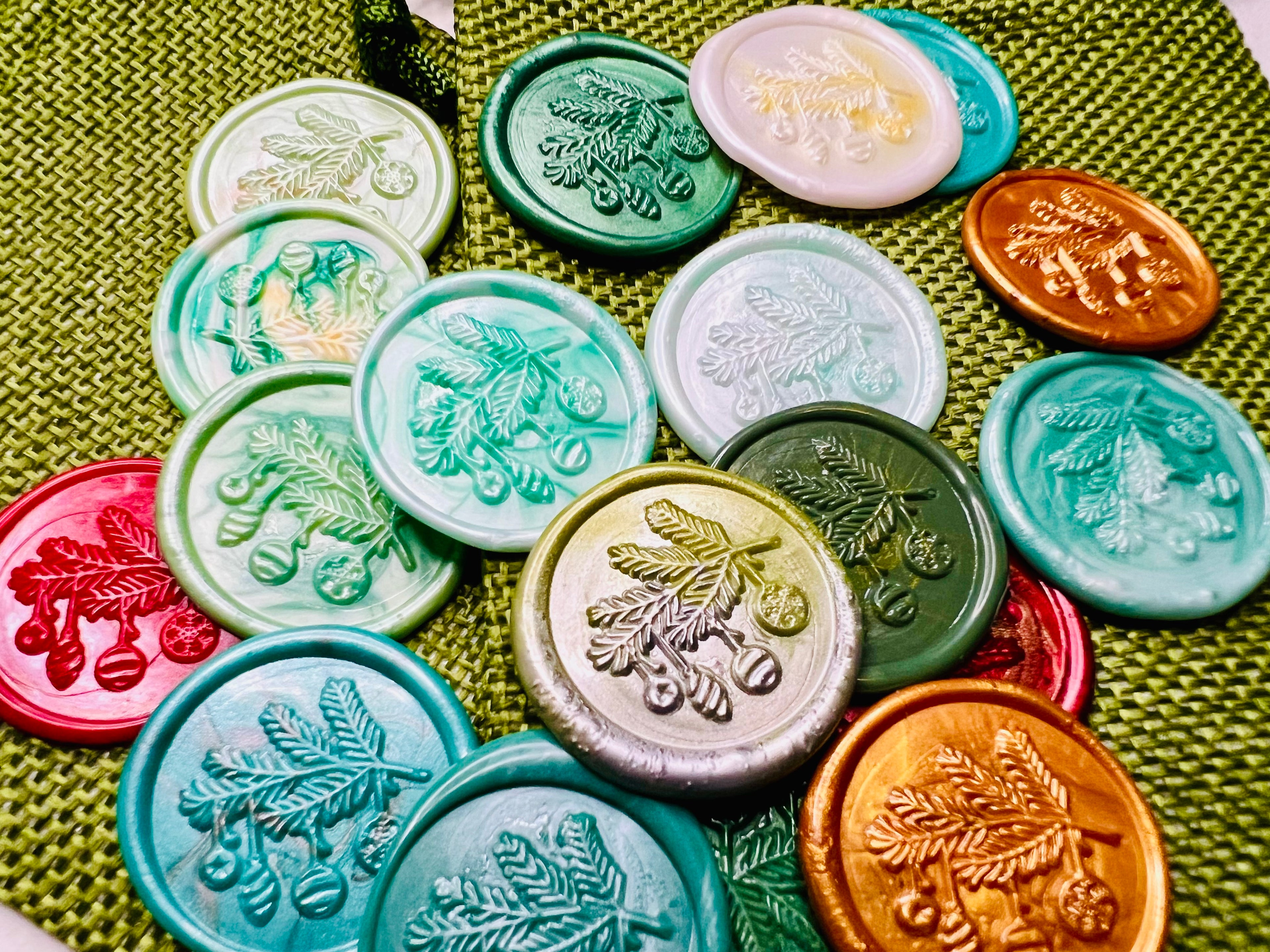 Close up view of the twinkling Christmas wax seal stickers on a green burlap bag