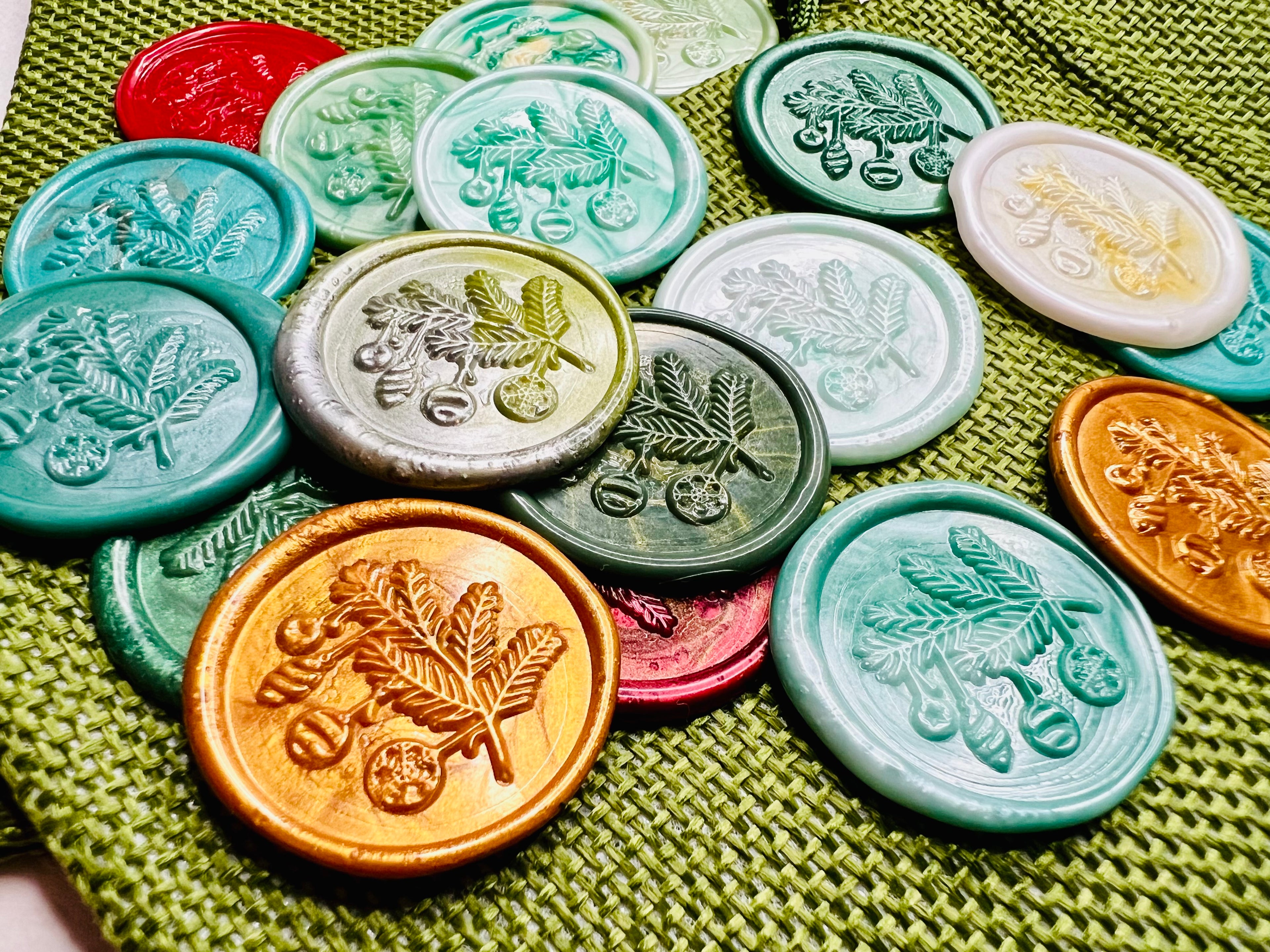 Up close view of the twinkling Christmas wax seal stickers on a green burlap sack by Rochambeau Home