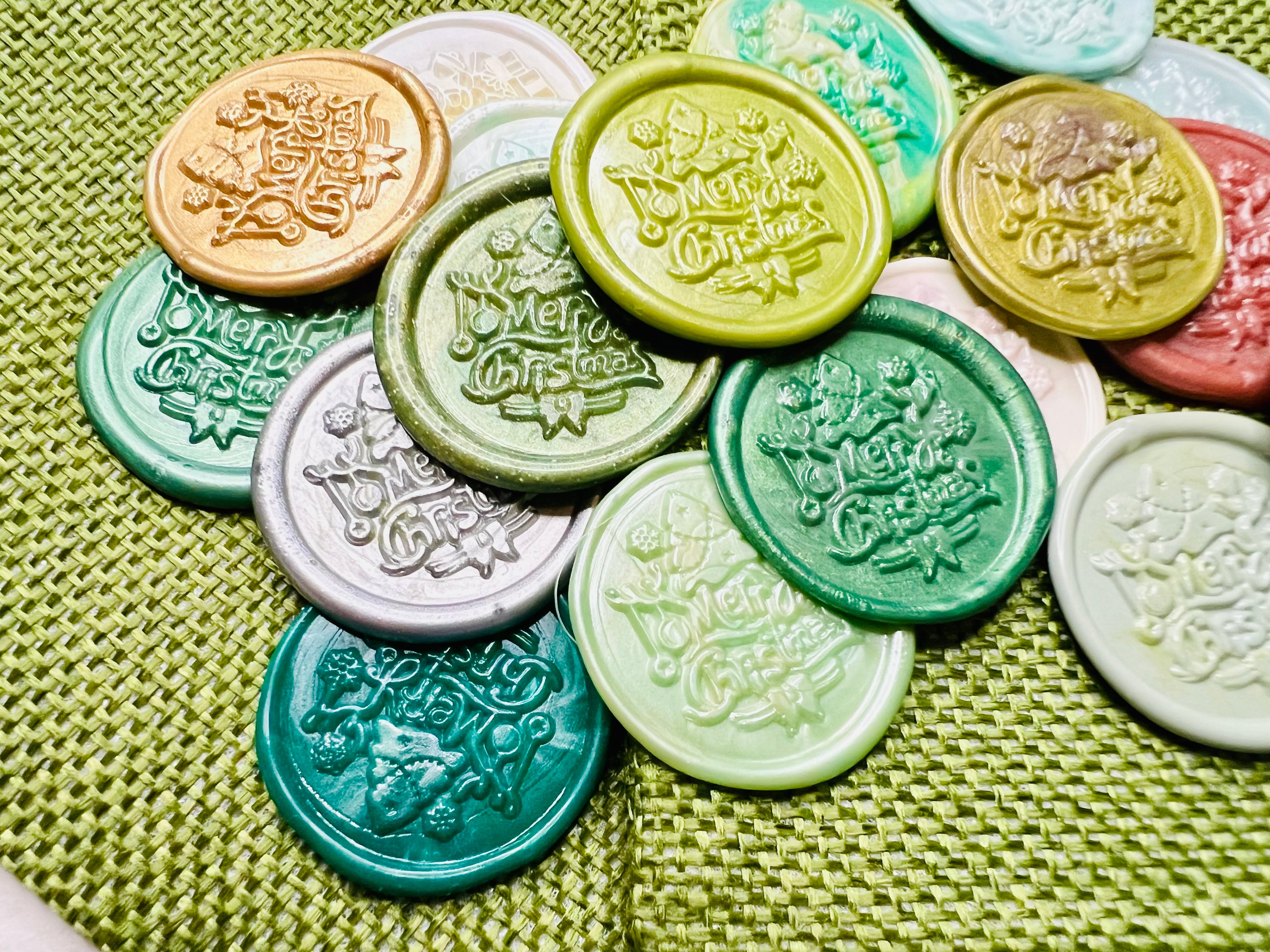 Close up view of the wax seal stickers by Rochambeau Home, showcasing “Merry Christmas” with a charming tree and presents in various colors.