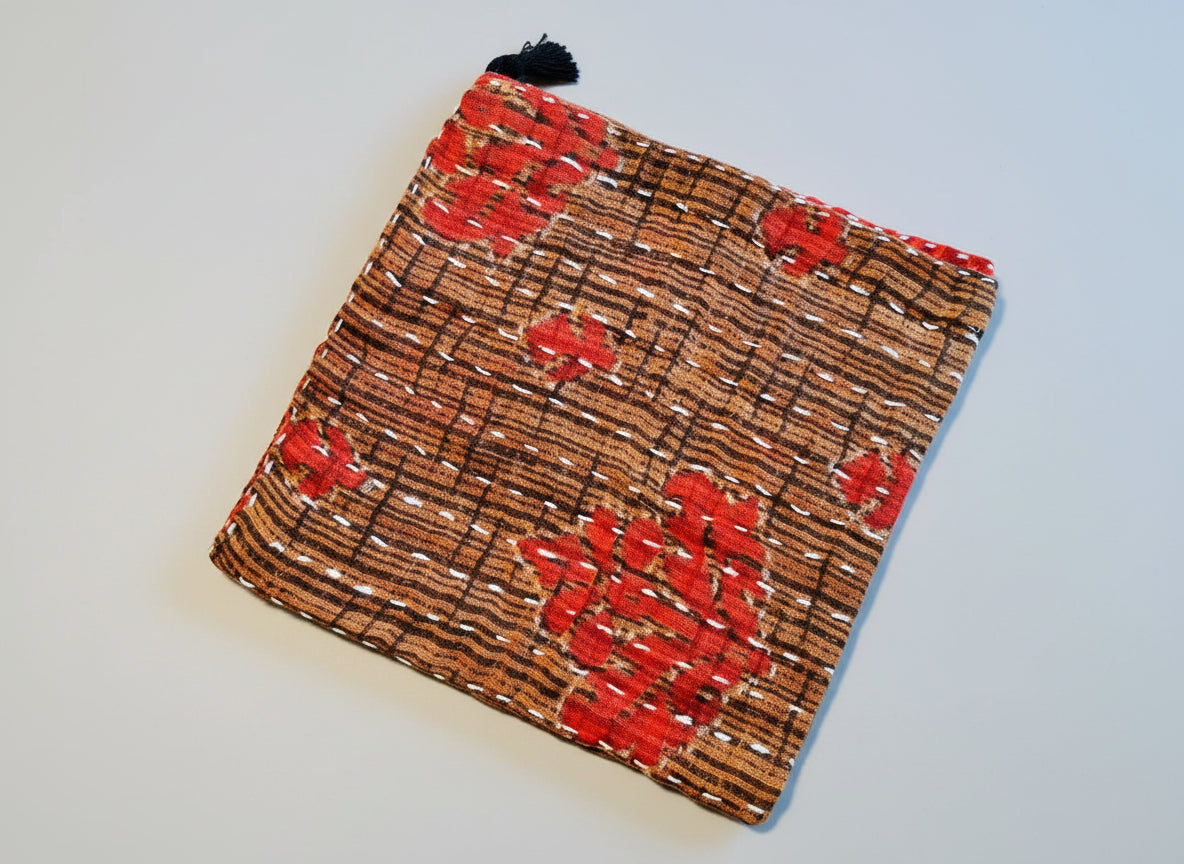 Geometric print Kantha dish cloth with red floral patterns.