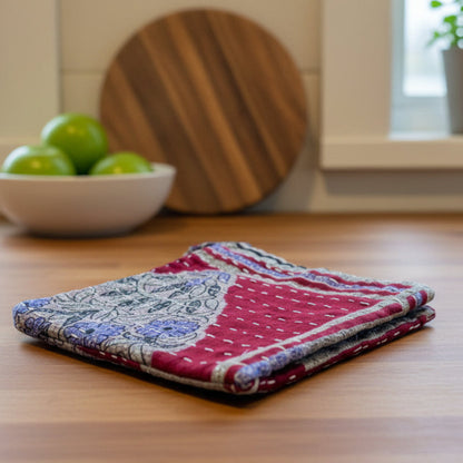 Embroidered red dish cloth with floral patterns on a white background