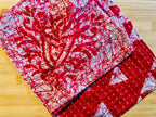 Red and white patterned towel on a wooden surface