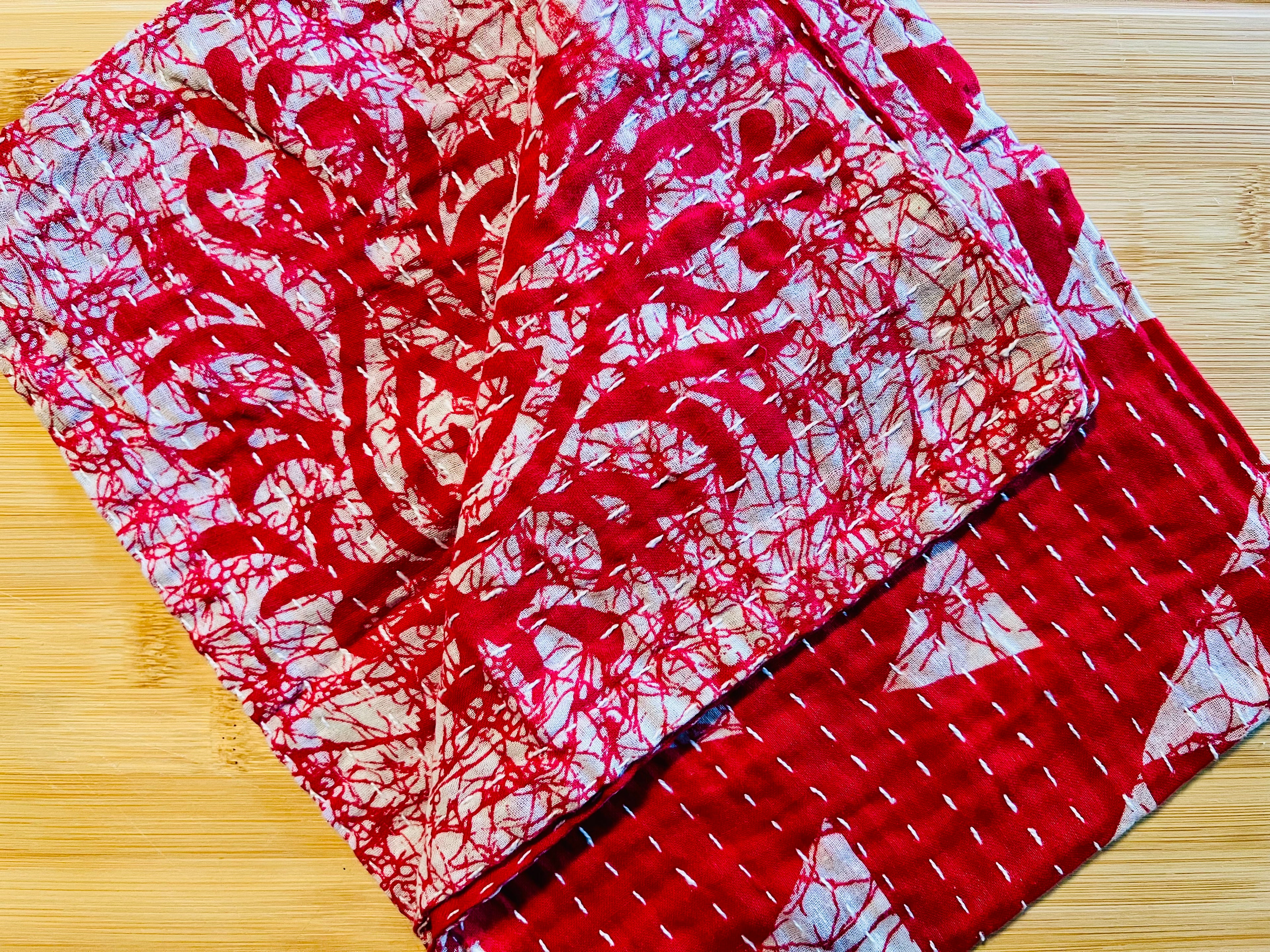Red and white patterned towel on a wooden surface