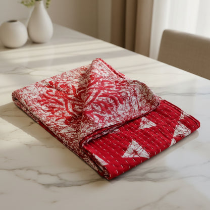 A vibrant red, white, and geometric patterned Kantha kitchen towel on a white background. 