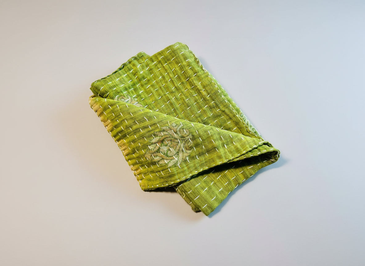 A soft green and floral patterned Kantha dish towel displayed on a neutral background.