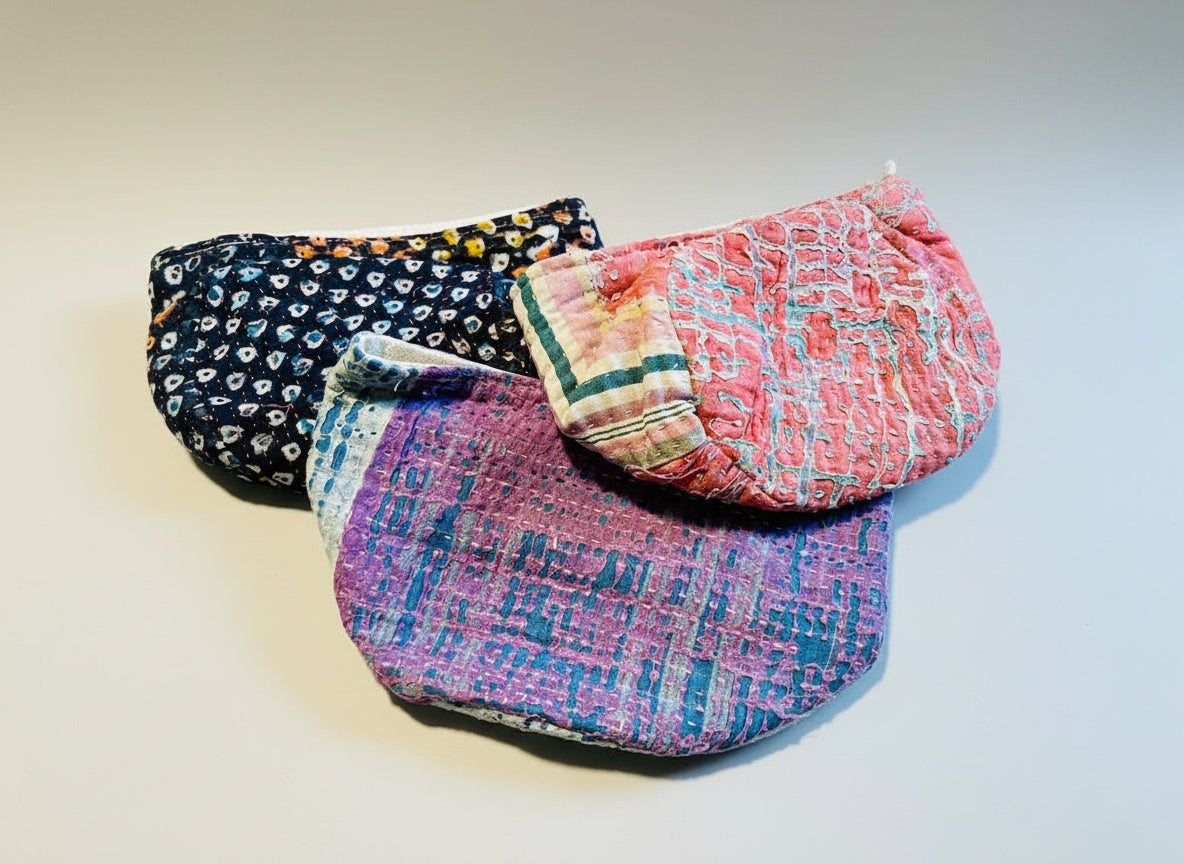 A colorful variety of Kantha baskets displayed on a gray background.