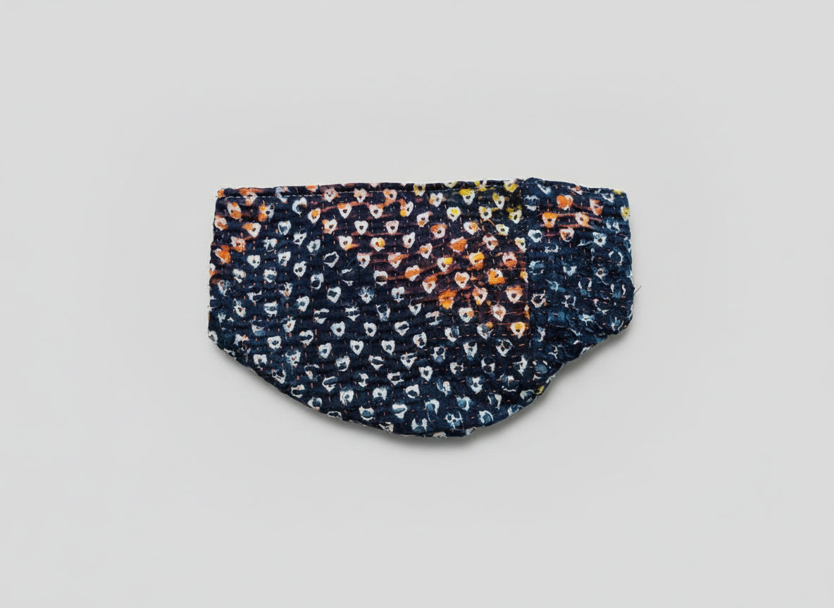 A beautiful heart patterned Kantha basket in various colors on a neutral background.