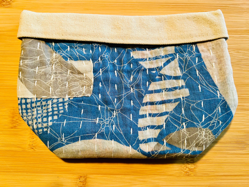 Fabric pouch with blue and white pattern on a wooden surface