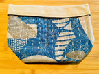 Fabric pouch with blue and white pattern on a wooden surface