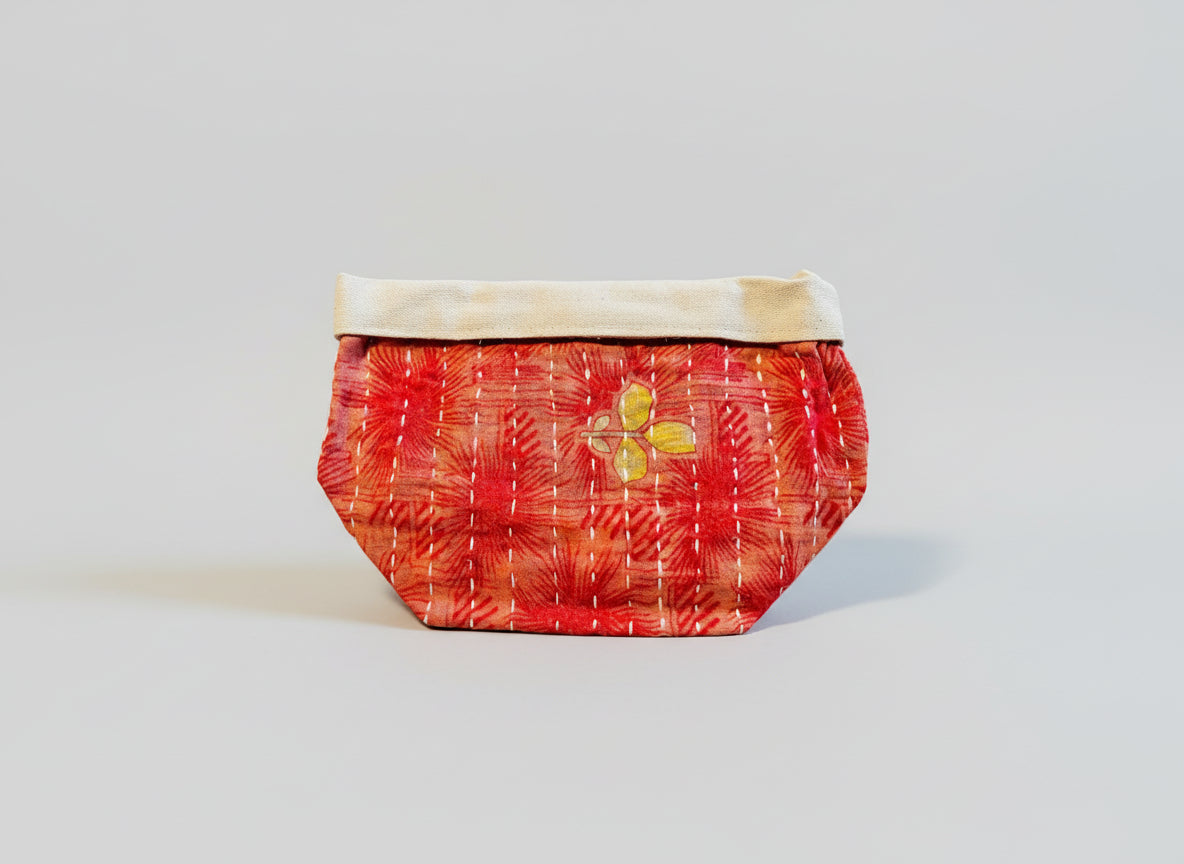 Red and floral patterned Kantha basket on a neutral background.