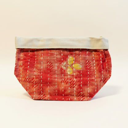 Red and floral patterned Kantha basket on a neutral background.