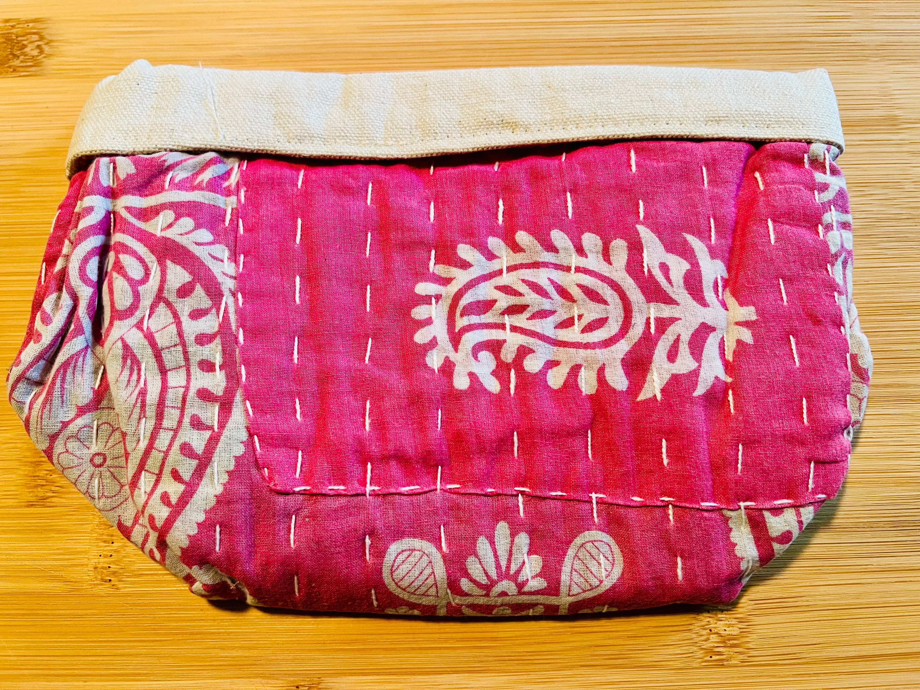 Pink and white patterned bag on a wooden surface