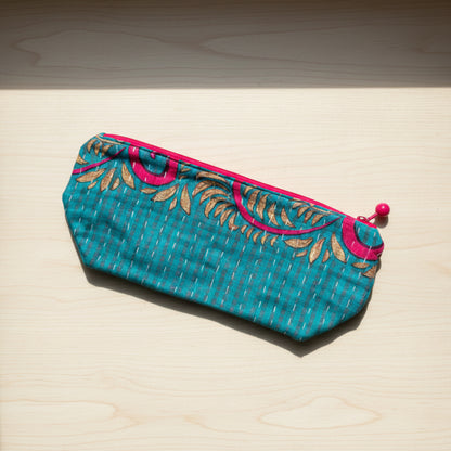 A large zippered Kantha cosmetic bag with turquoise, pink, and yellow accents on a neutral background. 