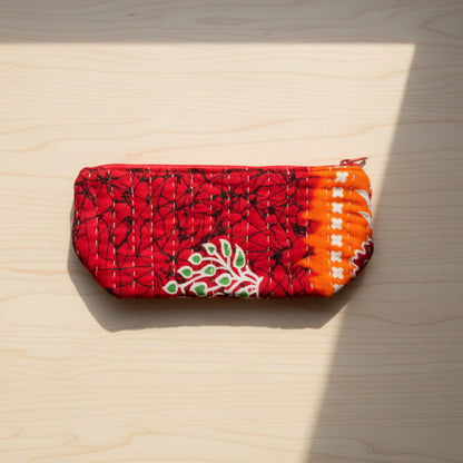 A large zippered Kantha cosmetic bag with red, green, and white geometric patterns.
