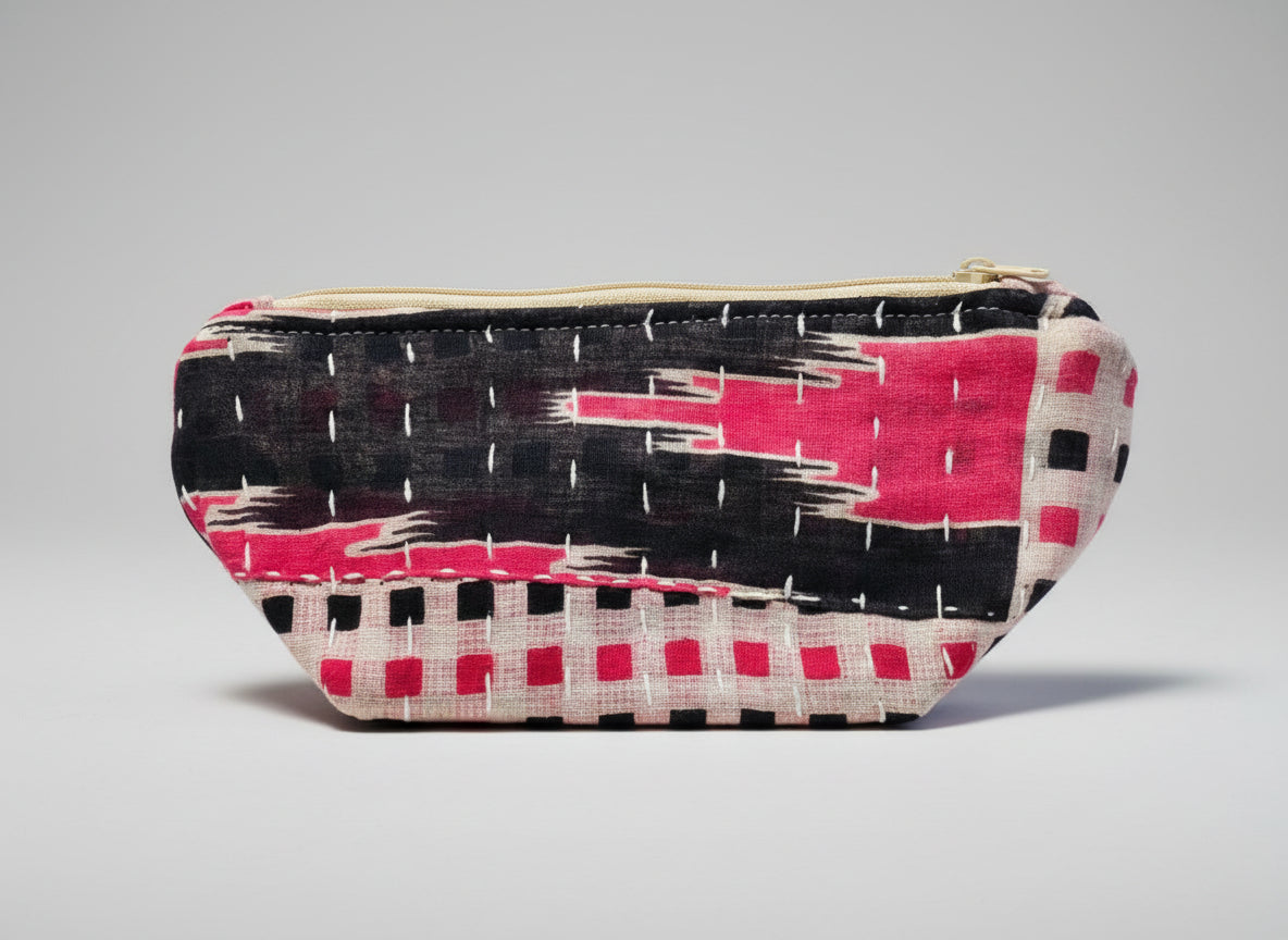 An abstract Kantha cosmetic bag with a black and pink geometric design on a neutral background.