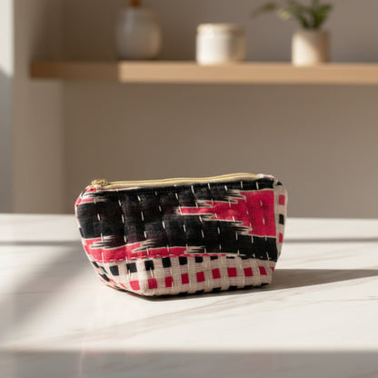 An abstract Kantha cosmetic bag with a black and pink geometric design on a neutral background.