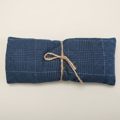 Blue woven pouch tied with string on a white background.
