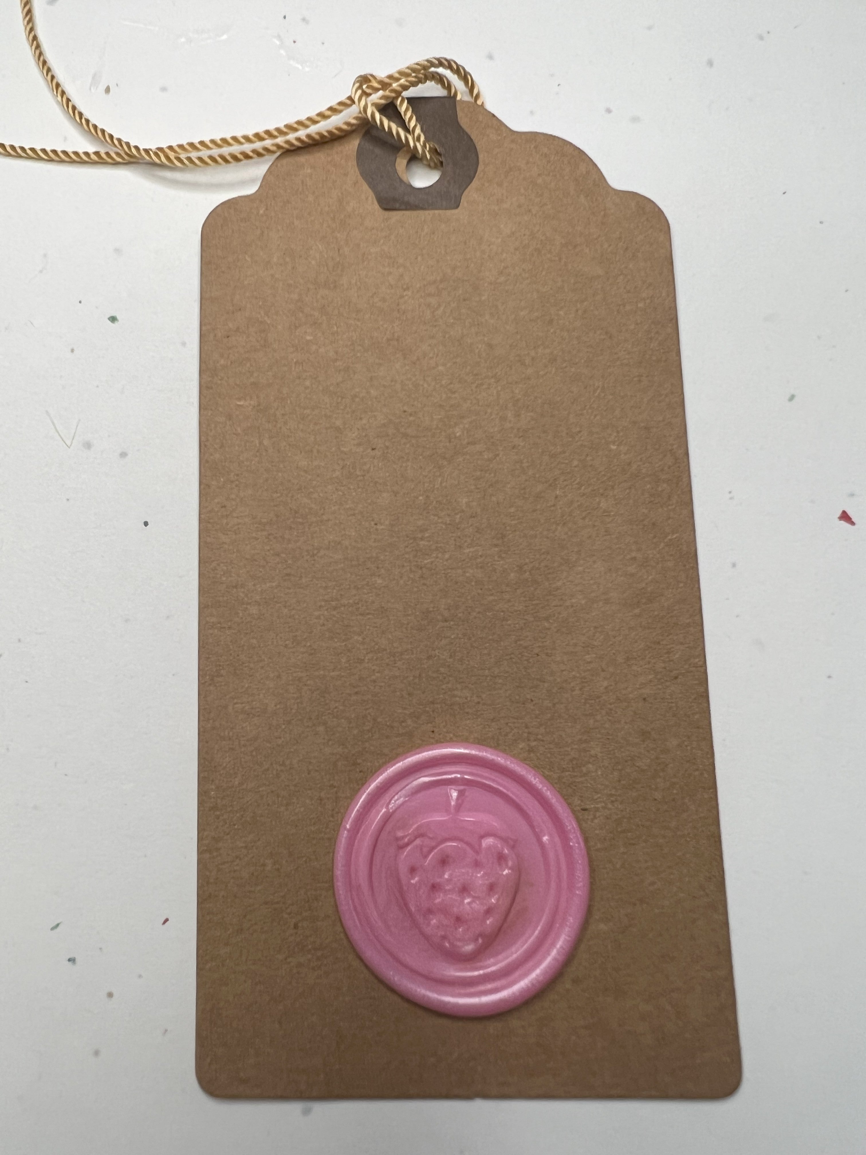 Glossy wax seal gift tags with berry motifs on kraft paper for a summery touch.