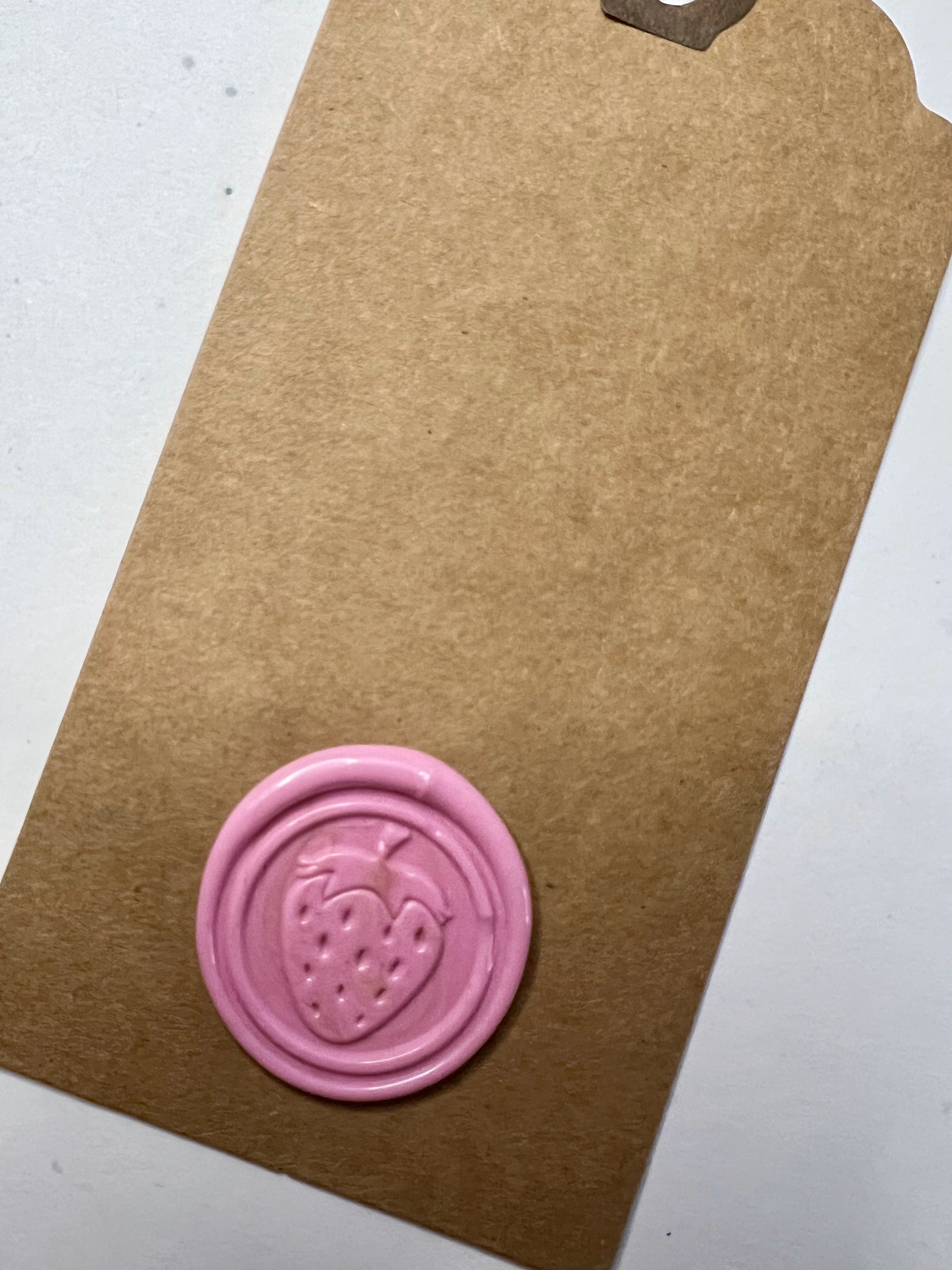 Fruity and fun wax seal tags featuring bright strawberry designs on rustic backgrounds.