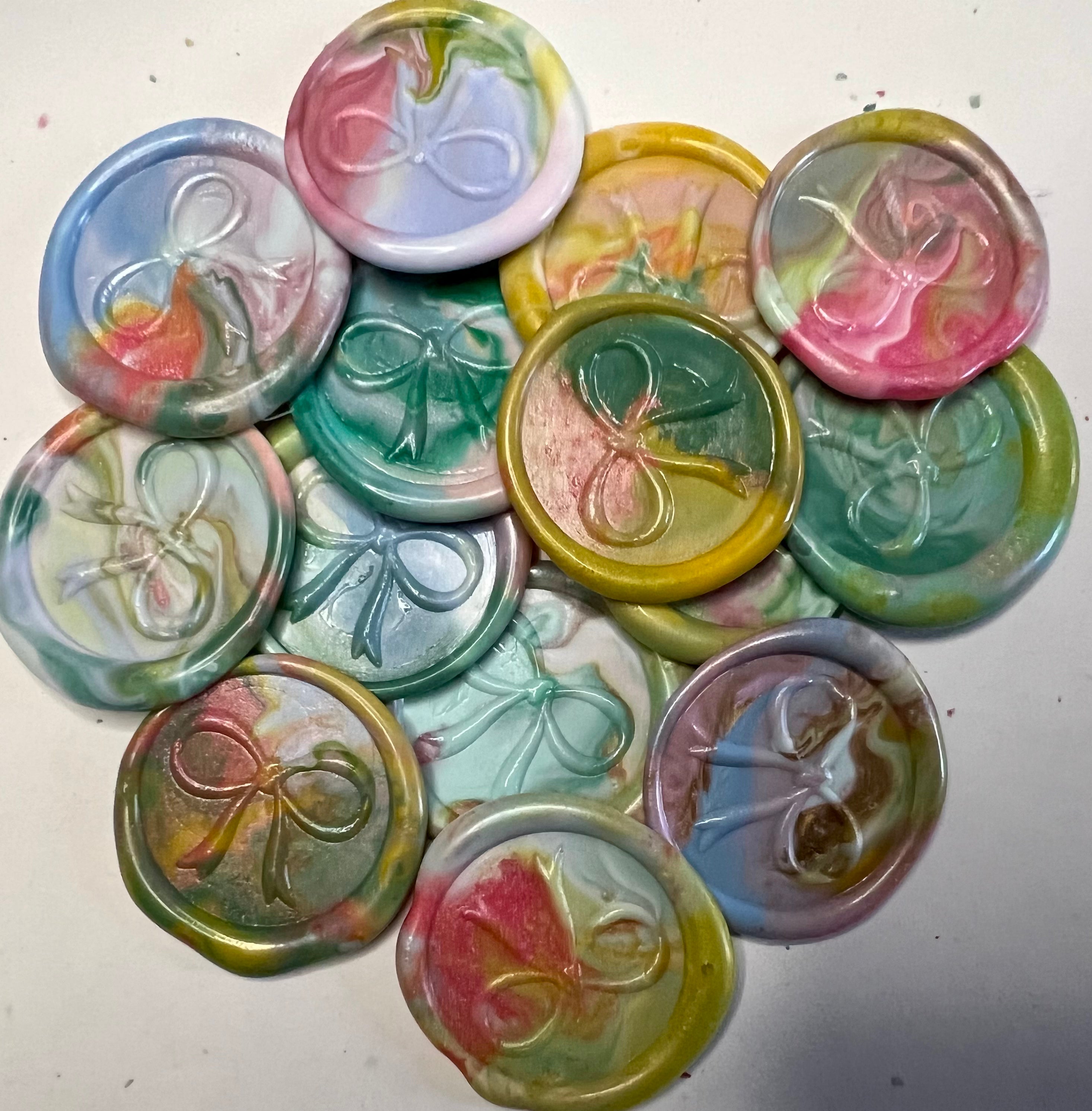 Shimmering rainbow wax seal tags with a bow motif, adding elegance to your gift wrapping for any occasion.