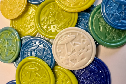 UFO embossed wax seal stickers created by Rochambeau Home in green, blue, and white colors. 
