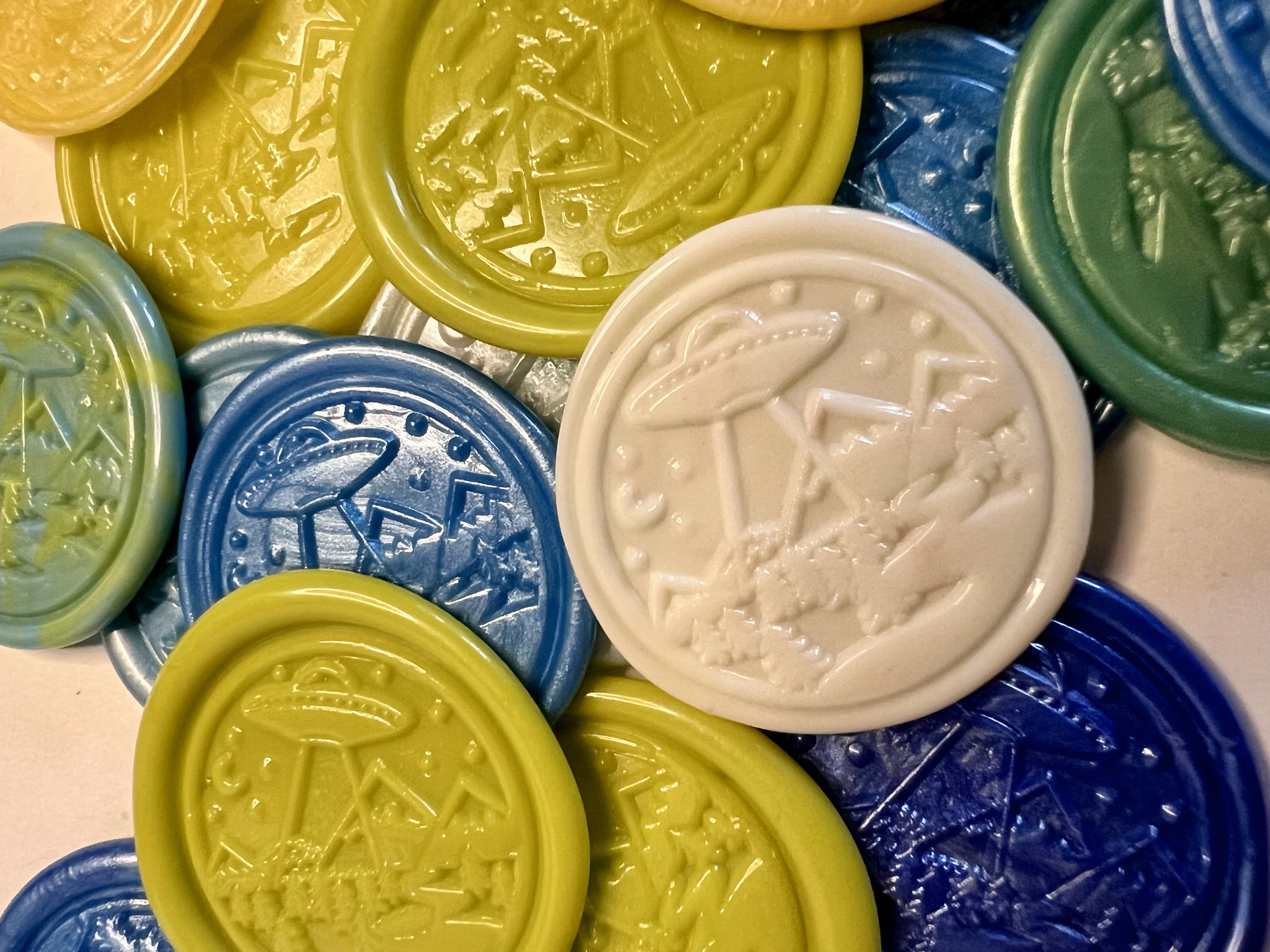 Close-up of embossed flying saucer design in multicolor wax