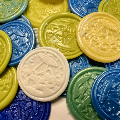 Colorful wax seal stickers with embossed UFO and space designs created by Rochambeau Home on a white background