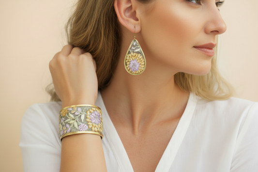 A woman wearing the yellow and lavender embroidered earring and bracelet set
