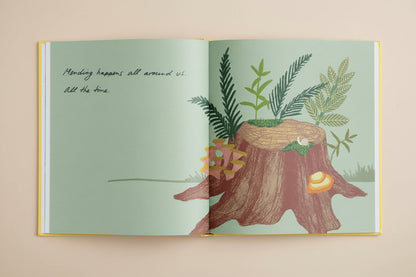 Illustrated book open to a page with a tree stump and plants on a light green background.