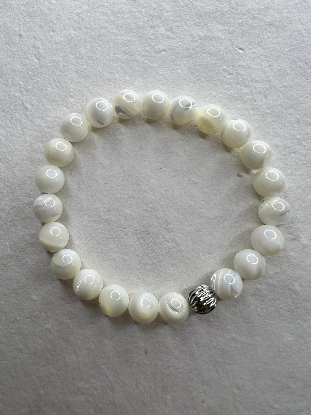 Mother of Pearl stretch bracelet with stainless steel beads on neutral background