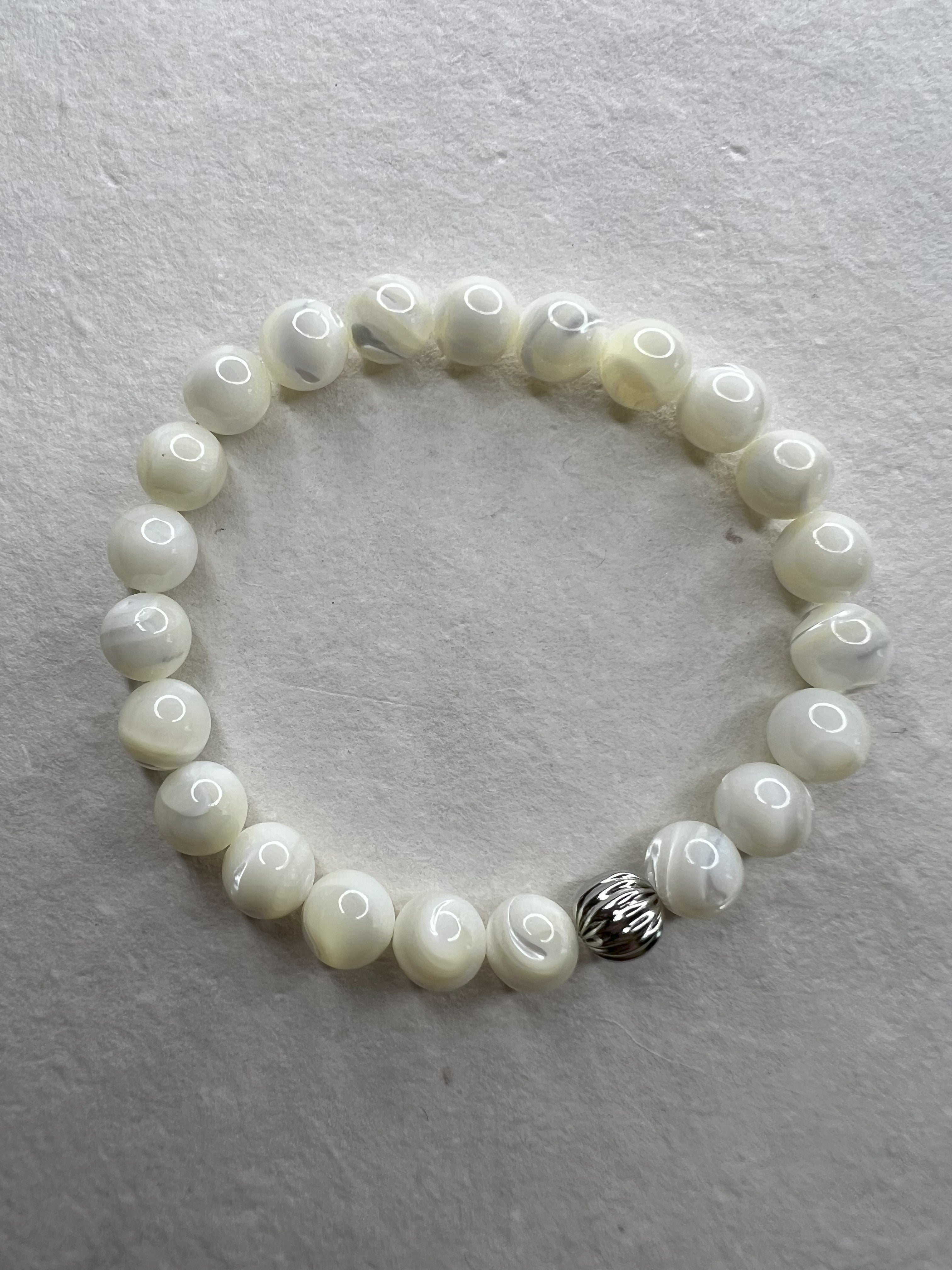 Mother of Pearl stretch bracelet with stainless steel beads on neutral background