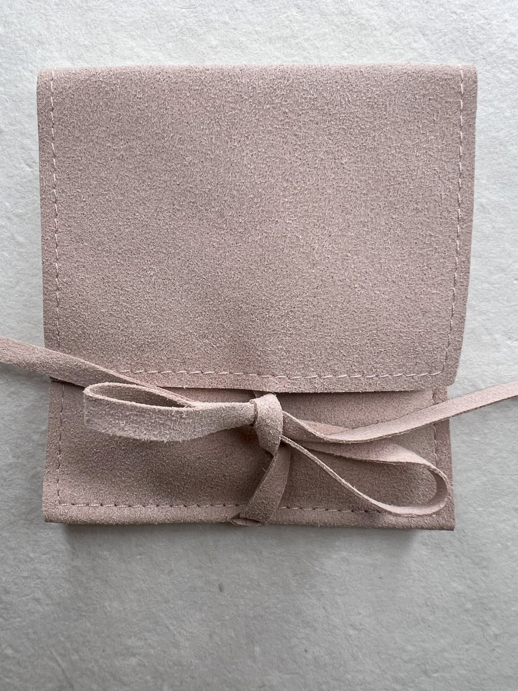 Close up view of the Mother of Pearl bracelet in suede packaging