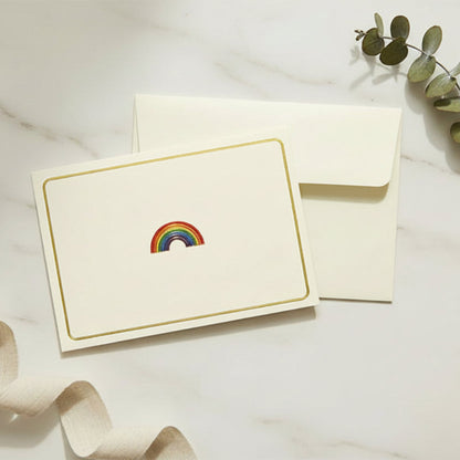 View of the Rainbow embossed card laying flat on a desktop with self seal envelope included