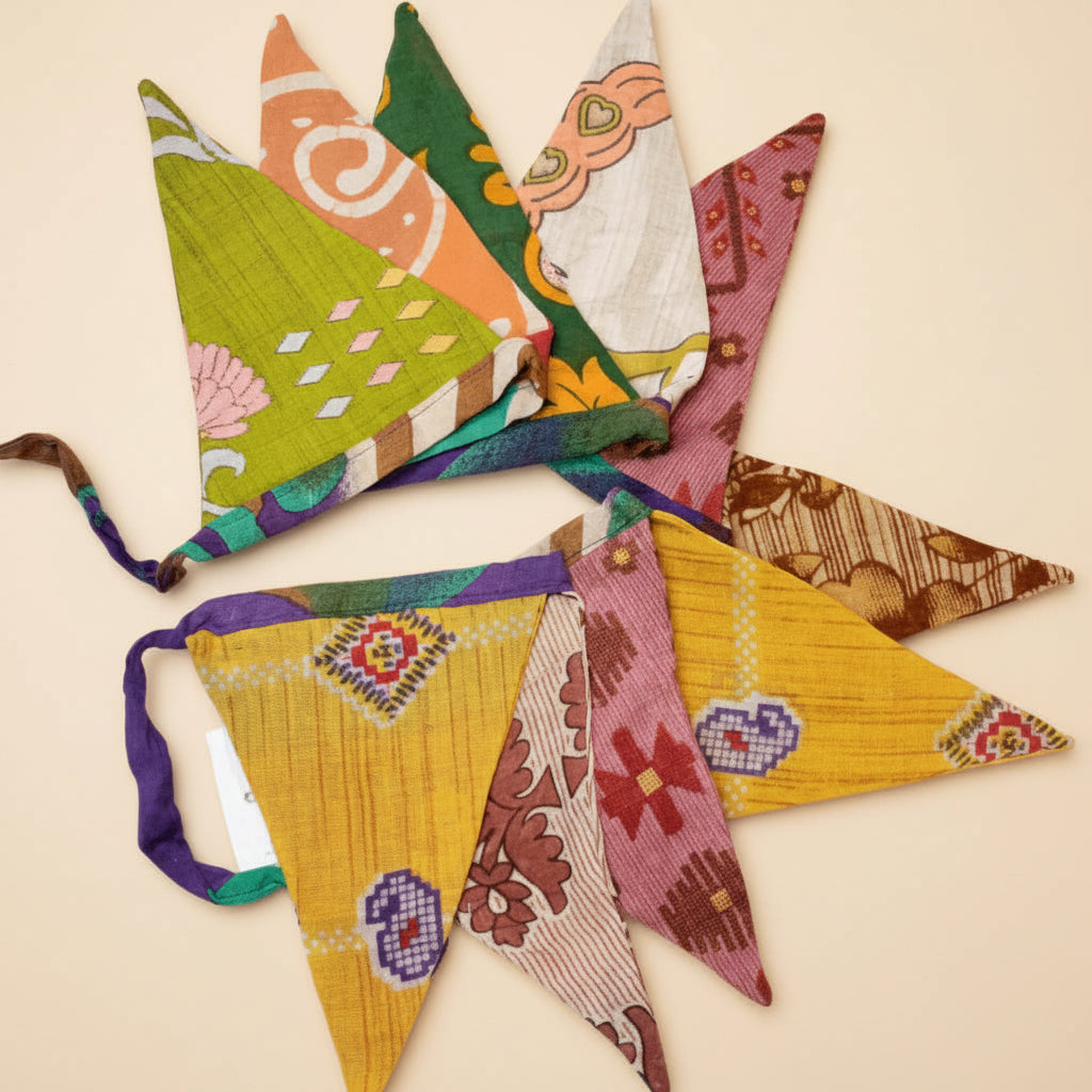 Colorful recycled saree fabric triangle garland arranged in a star shape on a white background