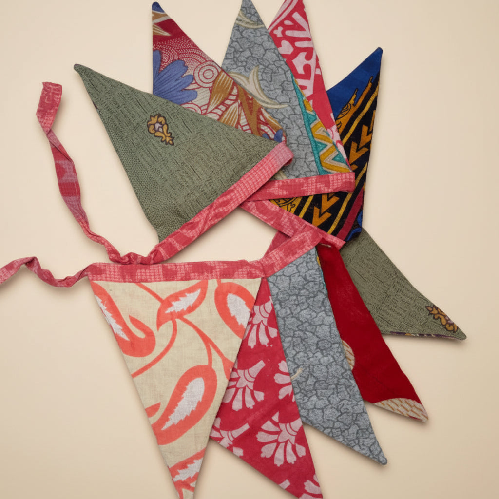 Colorful sari fabric triangle garland with various designs arranged in a decorative pattern on a white background
