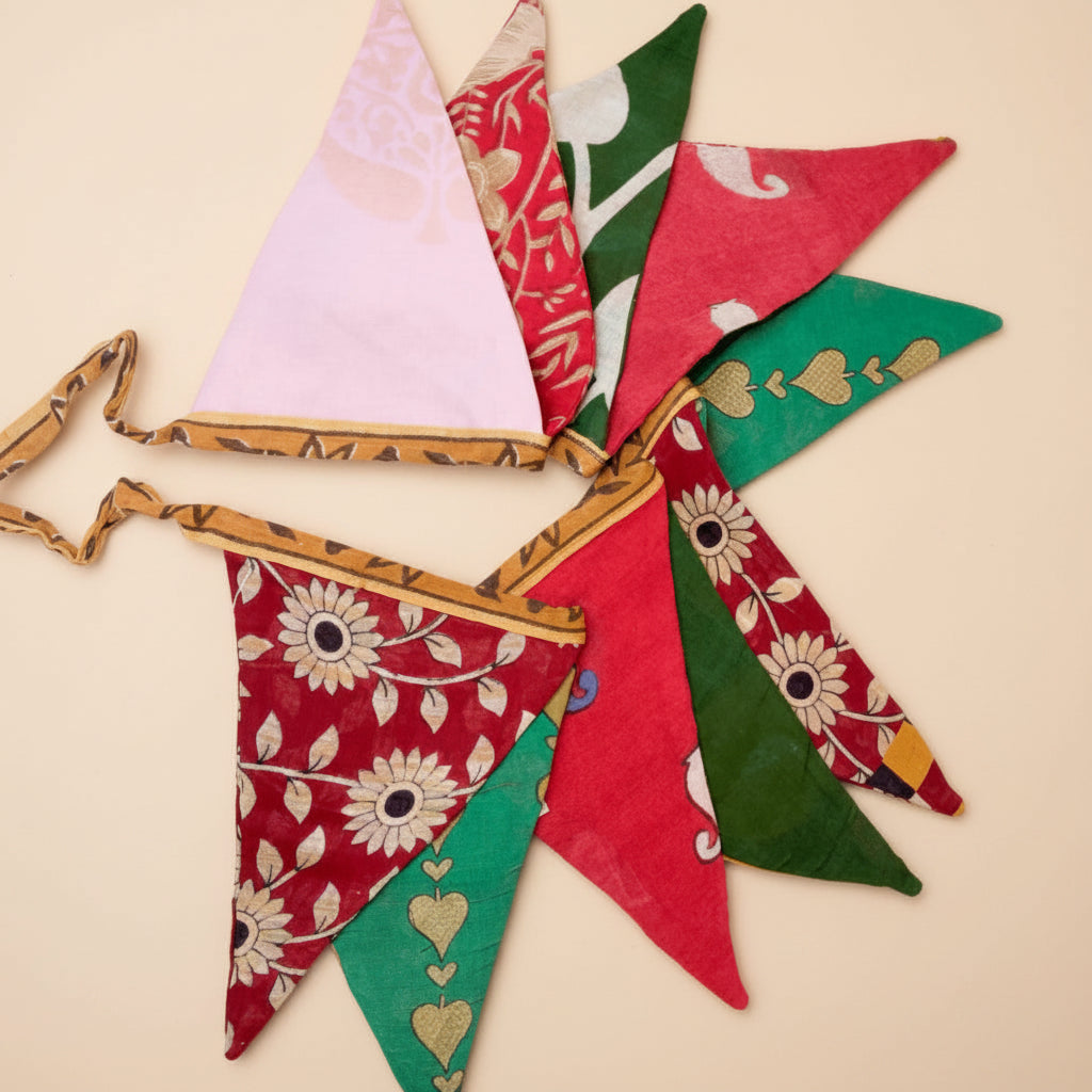 Colorful fabric triangle banner with floral and heart patterns on a white background