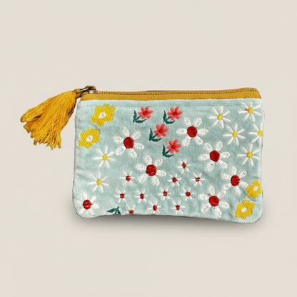 A bright and floral coin purse with blue velvet and a yellow tassel.