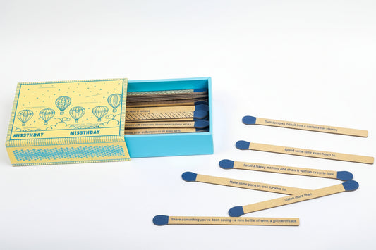 Faux matches with blue tips and printed text, in a box with a yellow and blue design.