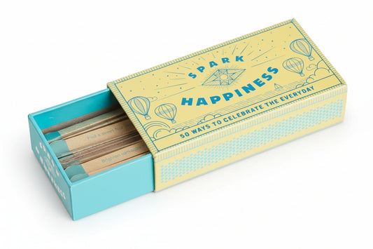 Matchbox with faux wooden matches and 'Spark Happiness' text on a white background