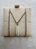 Close-up of iridescent teardrop pendant and silver chain
