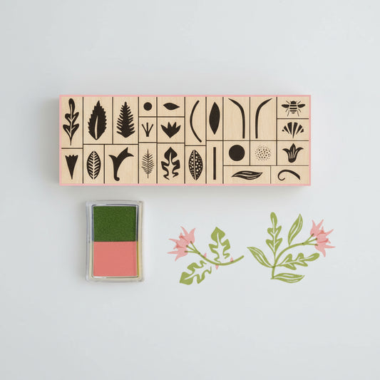 Botanical rubber stamp set in a matchbox-style box with floral illustrations and soft-toned ink pads