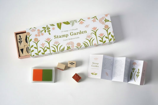 Botanical rubber stamp set in a matchbox-style box with floral illustrations and soft-toned ink pads