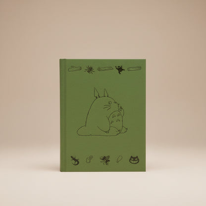 Green Totoro book cover with black line art of a character and various small illustrations on a white background