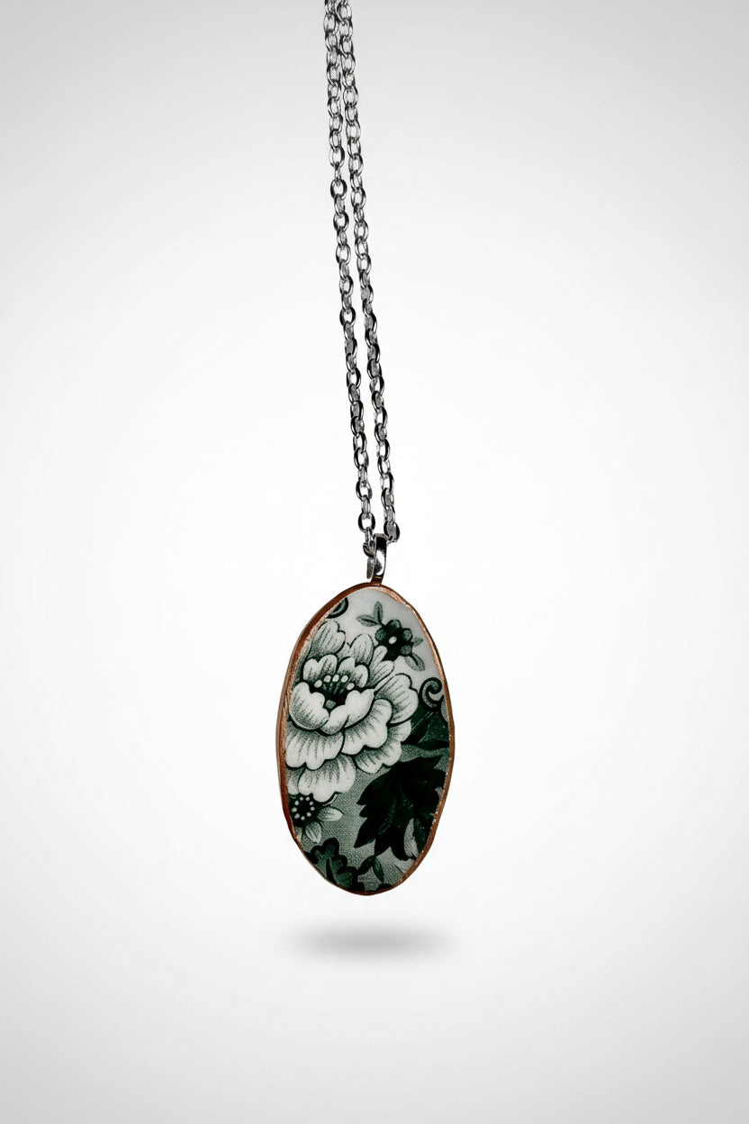 Floral green and white pendant necklace on a plain background